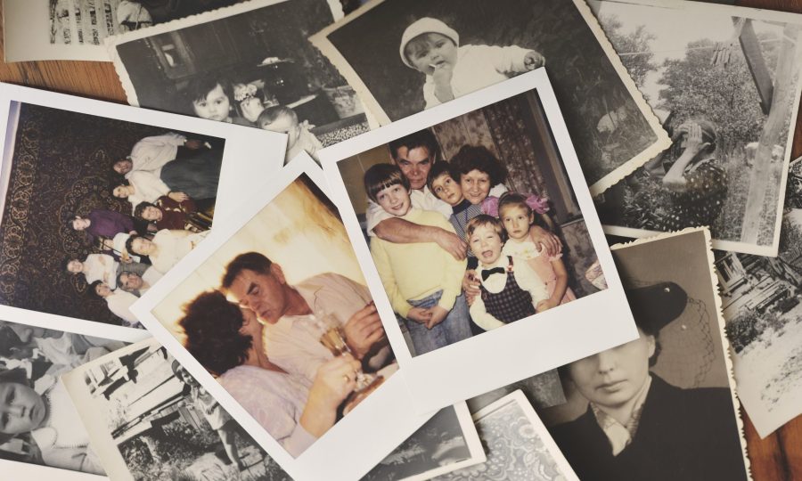 Pile of family photographs on table, overhead view Pile of family photographs on table, overhead view